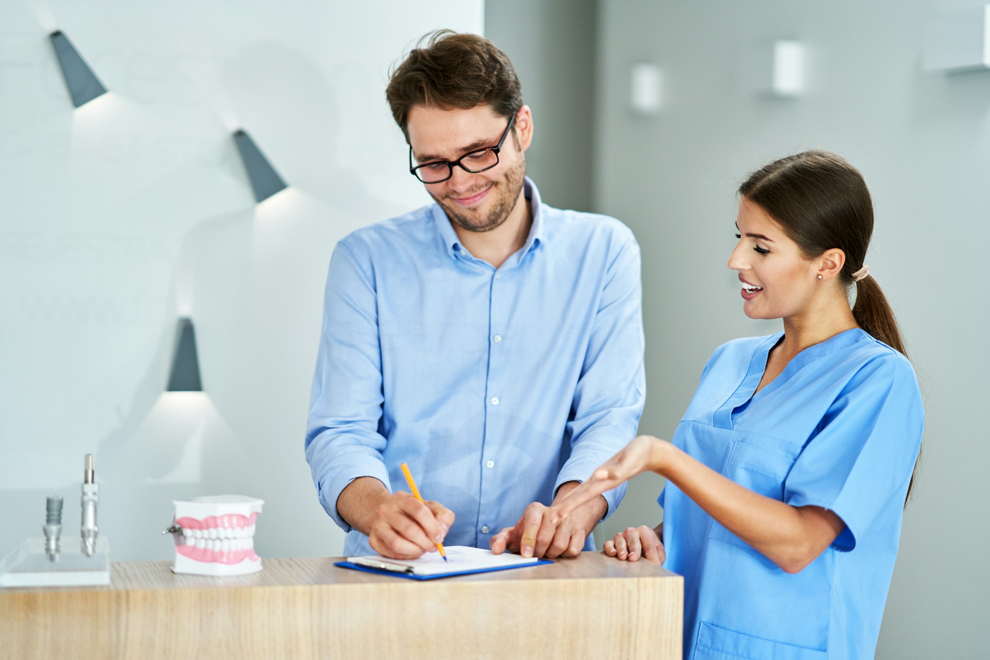 Patient signing documents in dental clinic
